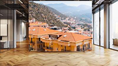 Houses and villas with red roofs in a resort town on mountain steep slope at the Mediterranean Sea. Real estate and urban development concept Wall mural