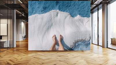 Men's feet on white calcite travertines with mineral water from thermal springs in Pamukkale, Turkey. The concept of Spa resorts and health of legs and feet Wall mural