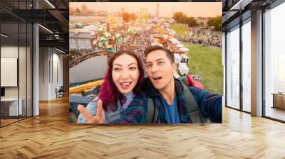 Tourist couple taking selfie photo at amusement fair and many eateries at a traditional festival on the park near bank of the Rhine river in Dusseldorf Wall mural