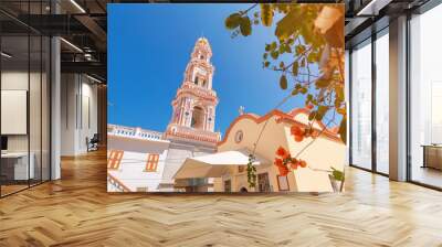 Tourists visiting famous monastery Panormitis on the island of Symi, Greece. Dodecanese sightseeing and mediterranean sea travel concept Wall mural