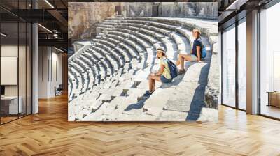 Two young girls student traveler enjoy a tour of the ancient Greek amphitheater Wall mural