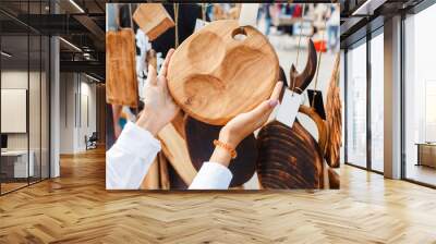 Woman choosing a cutting board in the outdoor flea handmade market Wall mural