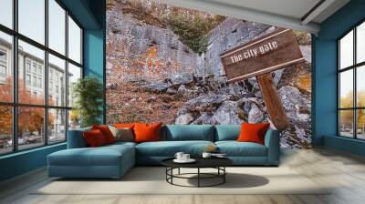 Wooden signpost marking city gate of an ancient city. Travel destination concept Wall mural