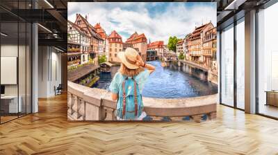 Young girl with backpack standing on a bridge over d Ill river in Strasbourg, France Wall mural