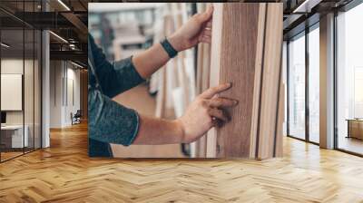 Male selects wooden floor of the sample in the specialized trade Wall mural