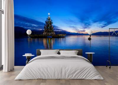 Christmas tree floating on a lake after sunset. Wall mural