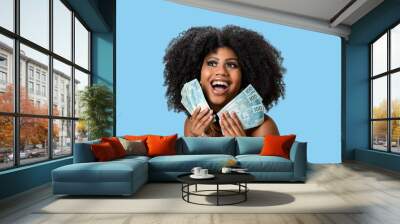  woman smiling holding brazilian money bills, positively surprised, space for text, person, advertising concept	 Wall mural