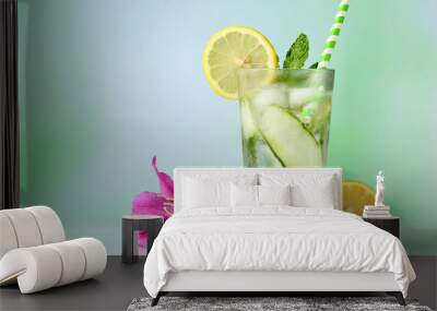 Refreshing long drink, decorated with Sicilian lemon, cucumber and mint, iced drink on a reflective green background Wall mural