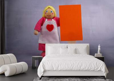 Wooden doll holding a red banner with a positive motivational message, symbolizing encouragement and support in an uplifting visual representation Wall mural