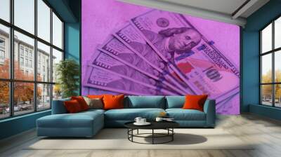 100 dollar bills in pink neon light. Wall mural