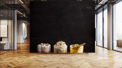 Hot chocolate, coffee and cider on wooden table on black background. Wall mural