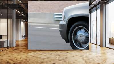 The front end of a silver, fast-moving vehicle circulating on a U.S. freeway, conveying the concepts of speed and travel Wall mural