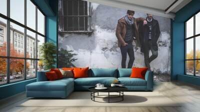 Portrait of two young man posing with fashionable winter clothes Wall mural