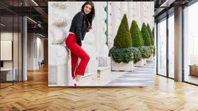 Beautiful girl posing against white building on the street Wall mural