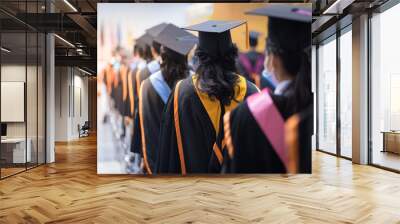 Rearview of the university graduates line up for degree award in university graduation ceremony. The university graduates are gathering in the university graduation ceremony. Crowd of the graduates. Wall mural