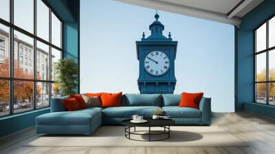 Historic clock tower against a clear blue sky at sunset in a peaceful urban setting Wall mural