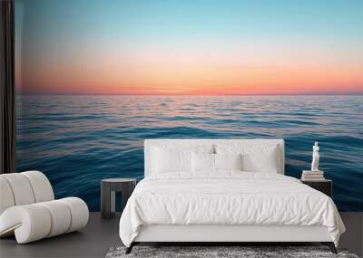 Tranquil ocean waves reflect a colorful sunset on the horizon near a calm sea in the evening Wall mural