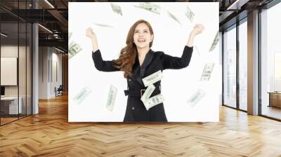 Portrait of happy Asian businesswoman standing under rain with falling down dollar bills banknotes isolated on white background. Concept of wealth and income. Wall mural