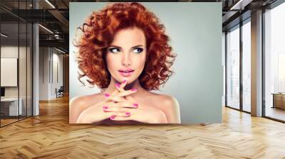 Beautiful model girl with curly red hair . Magenta   manicure on nails .
 Wall mural