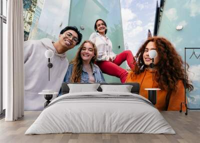 Group of happy young Gen Z friends standing in trendy and cool attitude smiling in the city  Wall mural