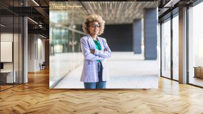 Happy successful black female professional smiling at camera. Young African American business woman with arms crossed standing in the office Wall mural