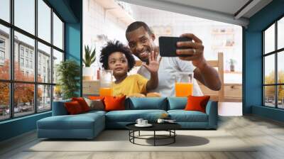 African American Father and kid boy doing video chat with mobile phone Wall mural