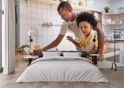 African American Little boy preparing food while his father looking on the digital recipe and using touch screen tablet in the kitchen Wall mural