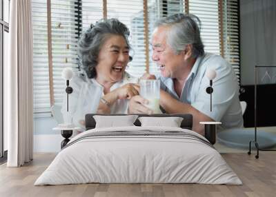 Asian senior couple in love drinking milk. Wall mural