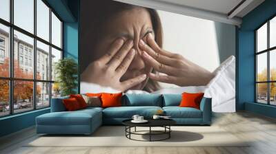 Asian woman rubbing eyes with her hands on her bed. Copy space. Wall mural