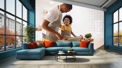 Black African American Father and son doing online cooking with digital tablet in kitchen Wall mural