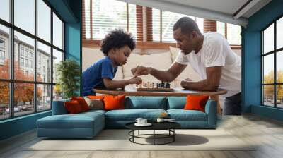 brazilian father and little boy playing chess on table at home together. happy black african america Wall mural