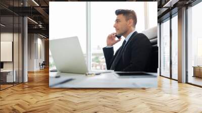 Concentrated Businessman is using cell phone. Wall mural