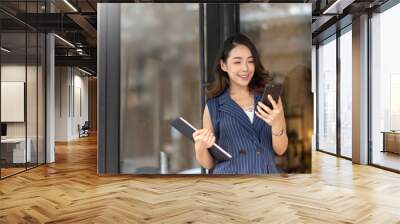 Confident Asian Young businesswoman working with smartphone outdoor. Wall mural