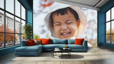 Portrait of Happy Asian Chinese little child boy wearing hat laughing outdoor. Wall mural