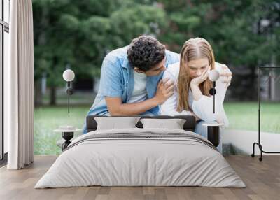 Hispanic boy comforting and hugging sad girfriend outdoors in a park. Wall mural