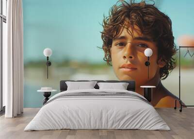 Portrait of hispanic teenager boy looking at camera in the beach Wall mural