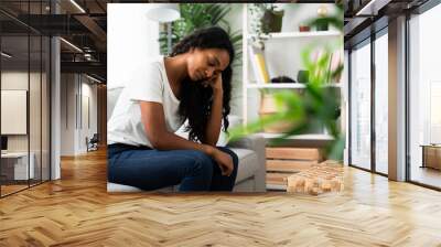 Sad Indian woman sitting on sofa. Depression and loneliness concept Wall mural