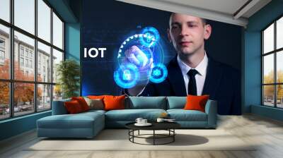 Business, Technology, Internet and network concept. Young businessman working on a virtual screen of the future and sees the inscription: IOT Wall mural