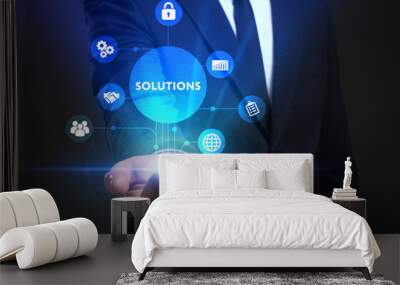 Business, Technology, Internet and network concept. Young businessman working on a virtual screen of the future and sees the inscription: Solutions Wall mural