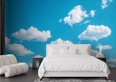 White fluffy clouds drift across a bright blue sky. Wall mural