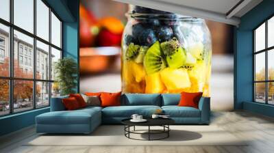 Colorful fruit salad in a jar on rustic wooden background Wall mural