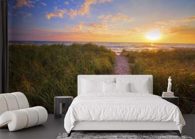 Path To A Summer Sunset Beach. Winding trail through dune grass leads to a sunset beach on the coast of the inland sea of Lake Michigan. Hoffmaster State Park. Muskegon, Michigan. Wall mural