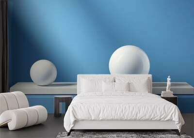 two spheres next to two cylinders on light blue table against dark and light blue background Wall mural