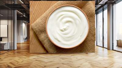 Delicious yogurt scene with wooden bowl and sackcloth. Closeup shot of healthy fresh yogurt. Top view. Wall mural