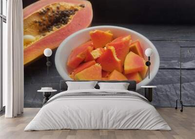 Papaya fruit slices In bowl and half of fresh papaya on the wooden table  Wall mural