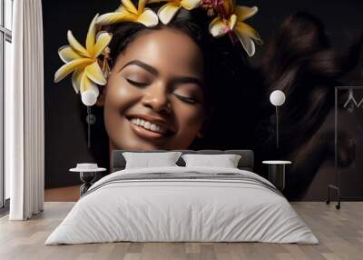 Black beautiful woman with frangipani flower in hair smiling Wall mural