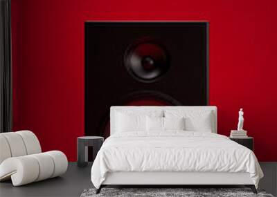 Black speaker isolated on red background Wall mural