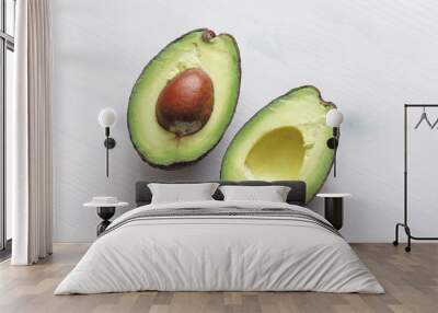 Avocado on a white wood background. Two halves of avocado and kernel, nut. Vegetarianism and healthy nutrition Wall mural