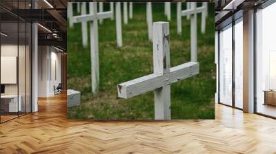 Lumivaara, Republic of Karelia. Old abandoned Finnish cemetery in Russia. Burial culture. Minimalistic background. White wooden crosses stand in row and green manicured lawn. Wall mural