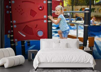 Adorable little girl on playground on a sunny day Wall mural